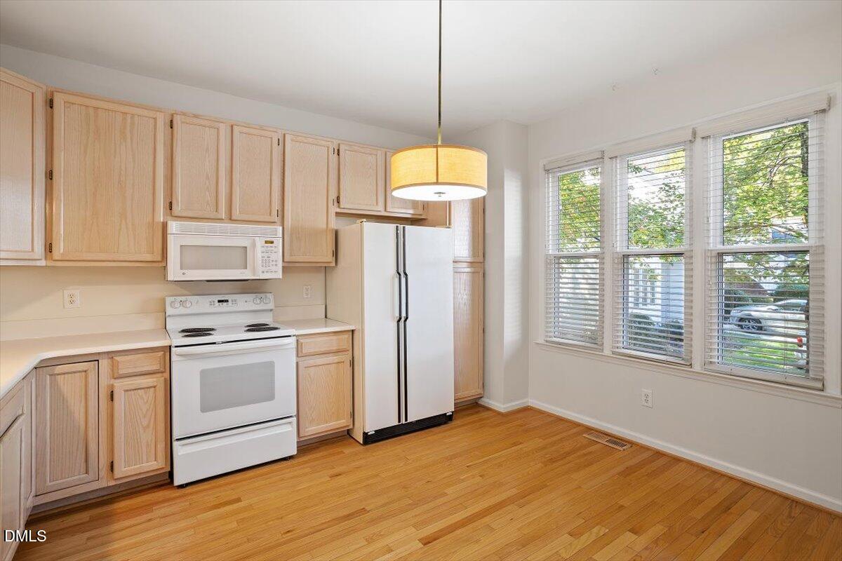 117 Colchis Court Cary, NC 27513 - Photo 11 of 39 a kitchen with appliances cabinets and a wooden floor