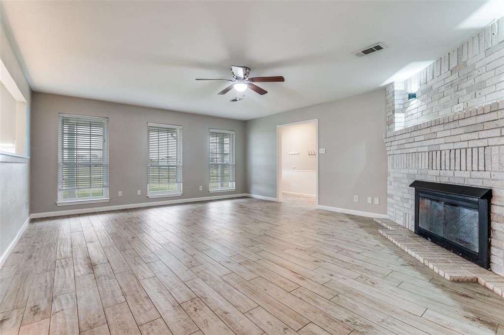 155 Smith Lane Combine, TX 75159 - Photo 11 of 31 Unfurnished living room featuring a ceiling fan, a fireplace, and light wood-type (tile) flooring