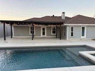 155 Smith Lane Combine, TX 75159 - Photo 25 of 31 Back of property at dusk with a patio, an outdoor pool, and a chimney