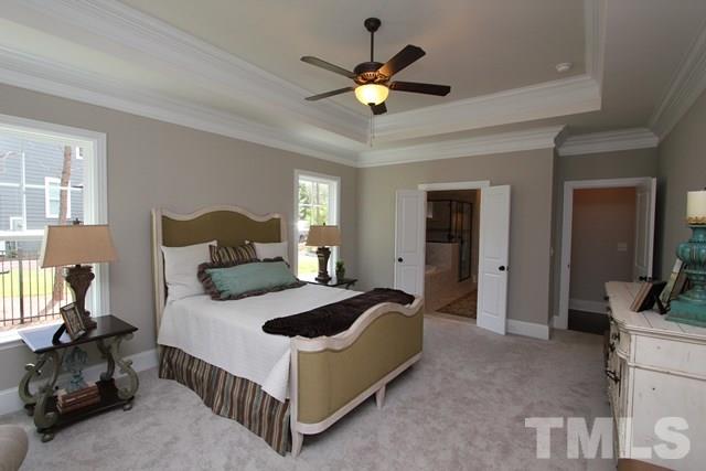 1221 Harrison Ridge Road Wake Forest, NC 27587 - Photo 12 of 25 a bedroom with a bed and a chandelier