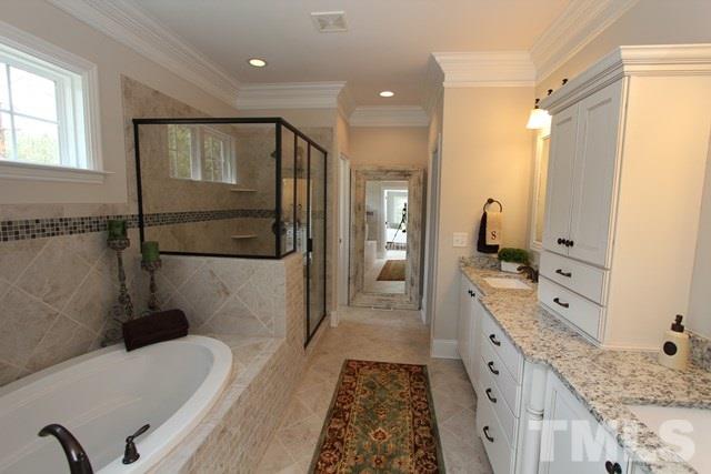 1221 Harrison Ridge Road Wake Forest, NC 27587 - Photo 13 of 25 a bathroom with a granite countertop sink a mirror and a bathtub
