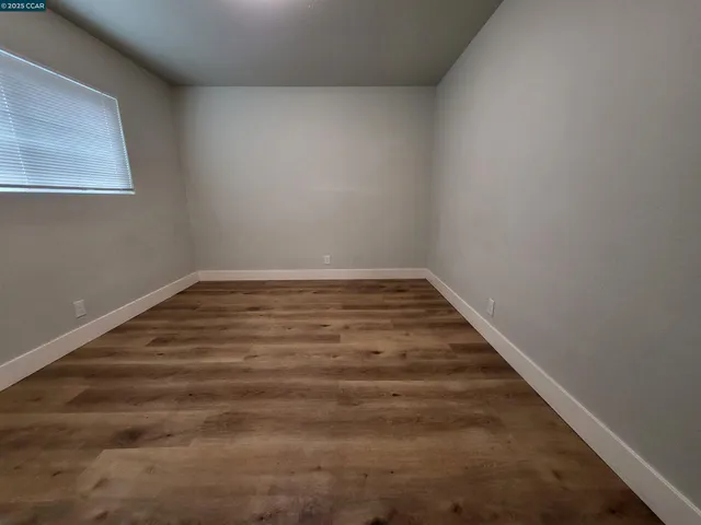 a view of a room with wooden floor and a window