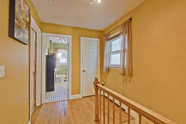 a view of a hallway with wooden floor and staircase