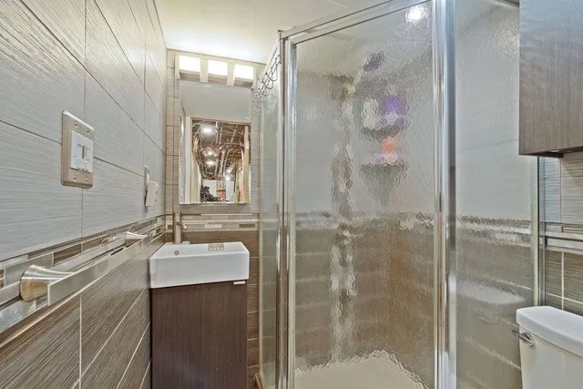 a bathroom with a shower sink and mirror