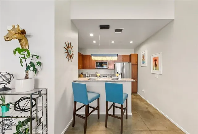 a living room with furniture a dining table and kitchen view with potted plants
