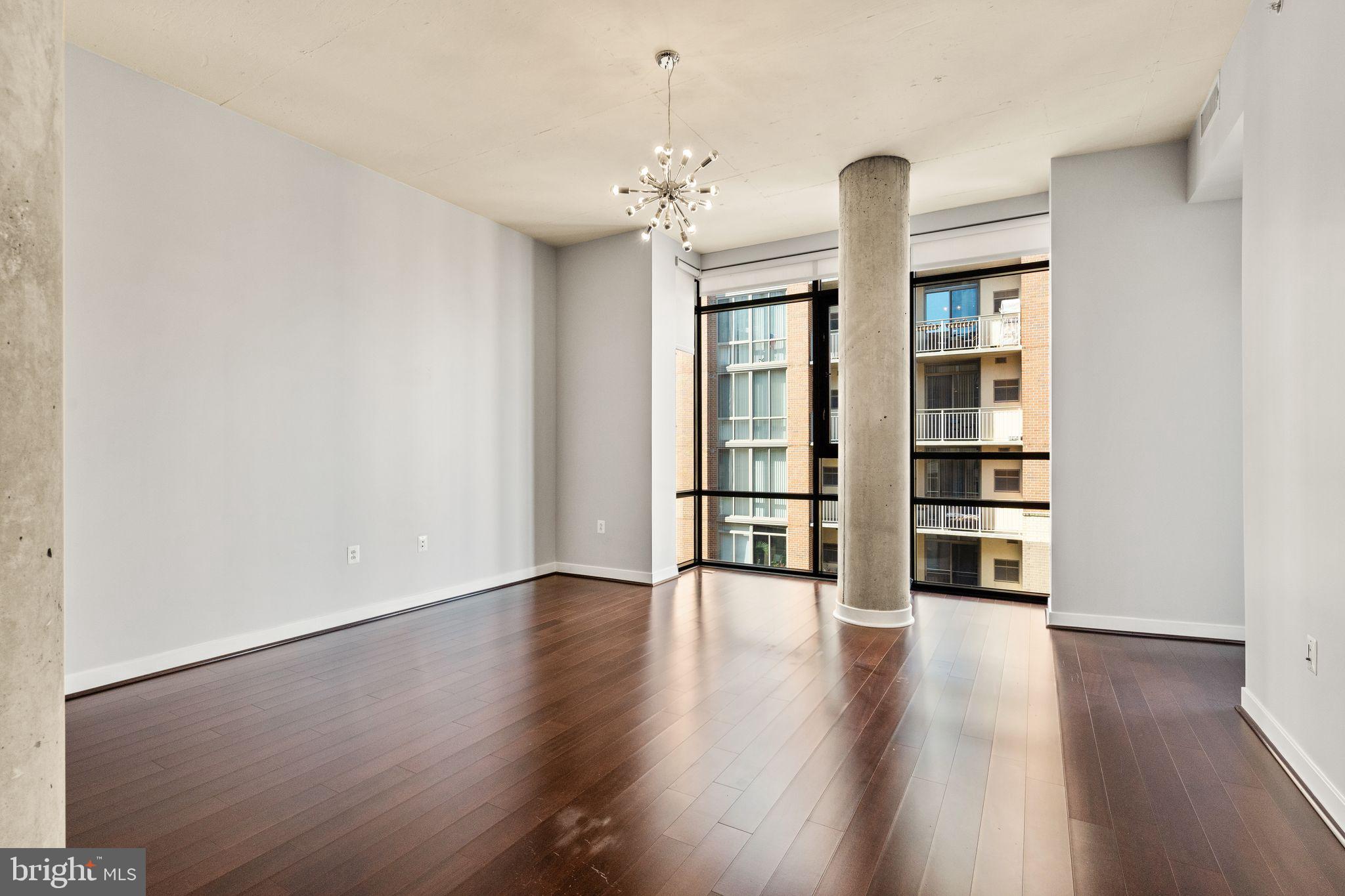 12025 New Dominion Parkway, Unit 406 Reston, VA 20190 - Photo 11 of 31 a view of an empty room with wooden floor and a window