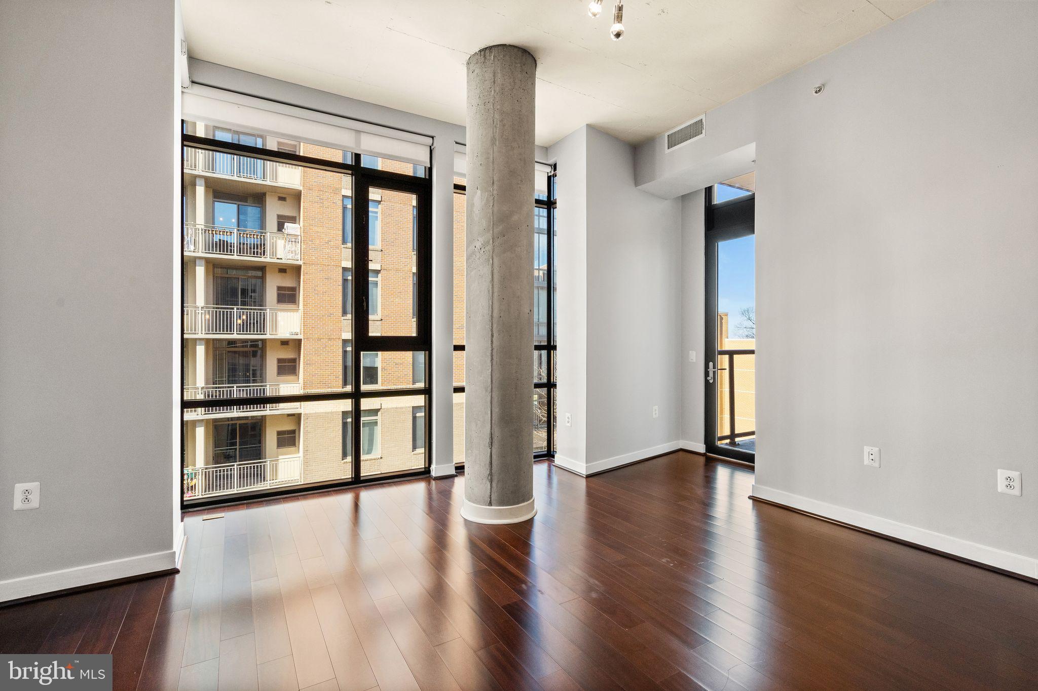 12025 New Dominion Parkway, Unit 406 Reston, VA 20190 - Photo 14 of 31 a view of an empty room with a window and wooden floor