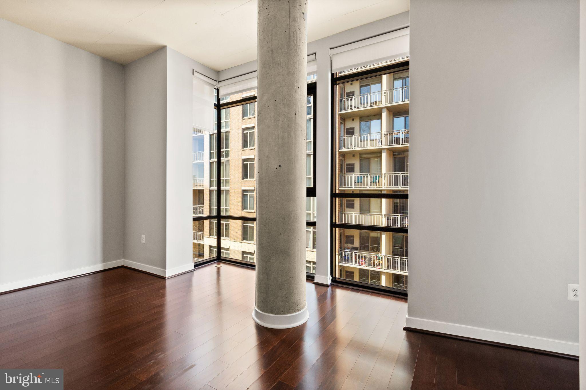 12025 New Dominion Parkway, Unit 406 Reston, VA 20190 - Photo 15 of 31 a view of an empty room with wooden floor and a window