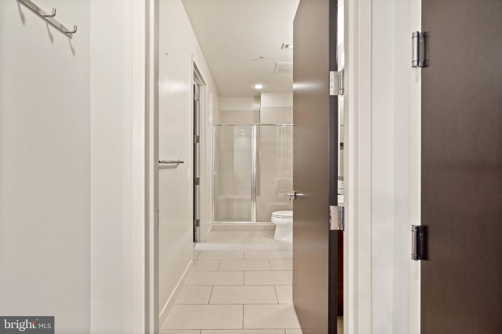 12025 New Dominion Parkway, Unit 406 Reston, VA 20190 - Photo 29 of 31 a bathroom with a glass shower door