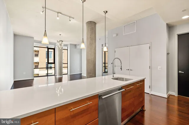 a kitchen with stainless steel appliances granite countertop a sink a refrigerator and a window