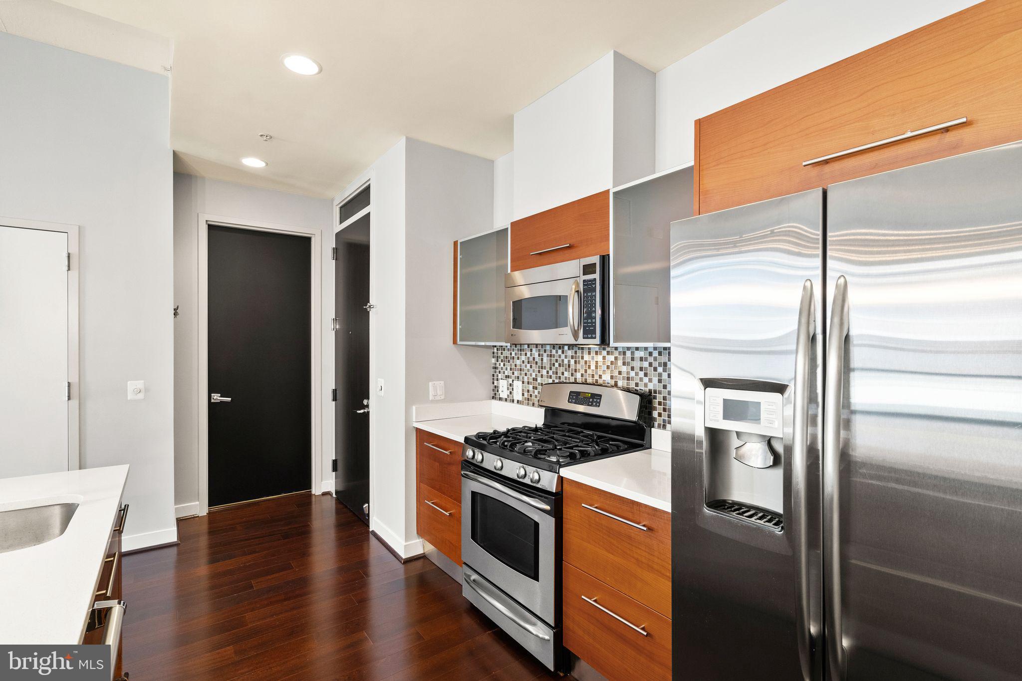 12025 New Dominion Parkway, Unit 406 Reston, VA 20190 - Photo 8 of 31 a kitchen with stainless steel appliances granite countertop a refrigerator and a stove