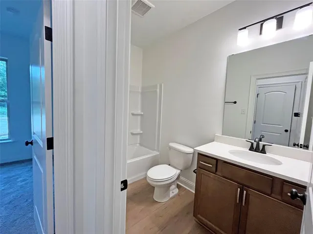 a bathroom with a sink a toilet a shower and a mirror