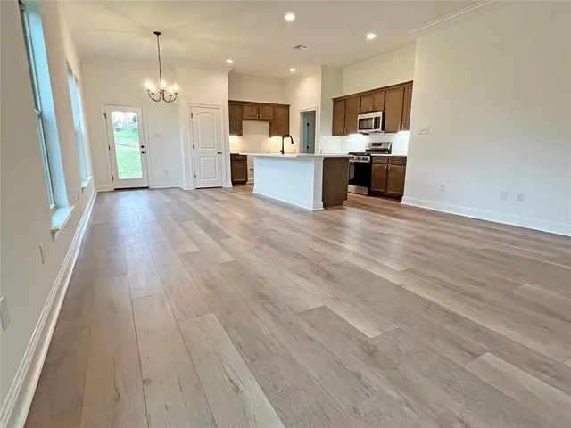 a view of kitchen with kitchen island wooden floor center island and cabinets