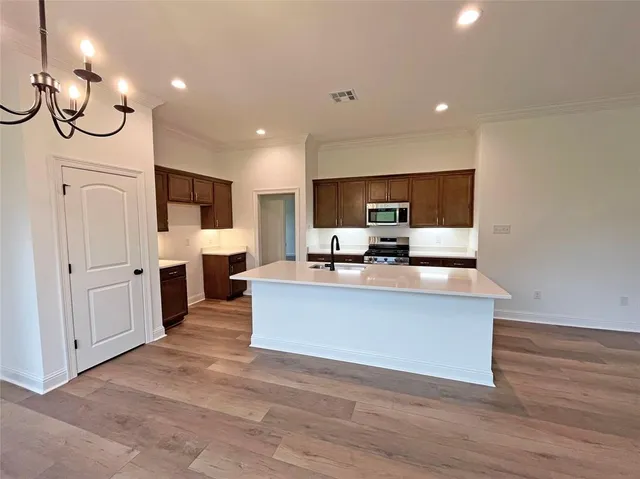 a living room with stainless steel appliances kitchen island granite countertop a living room a fireplace with wooden floor and cabinets