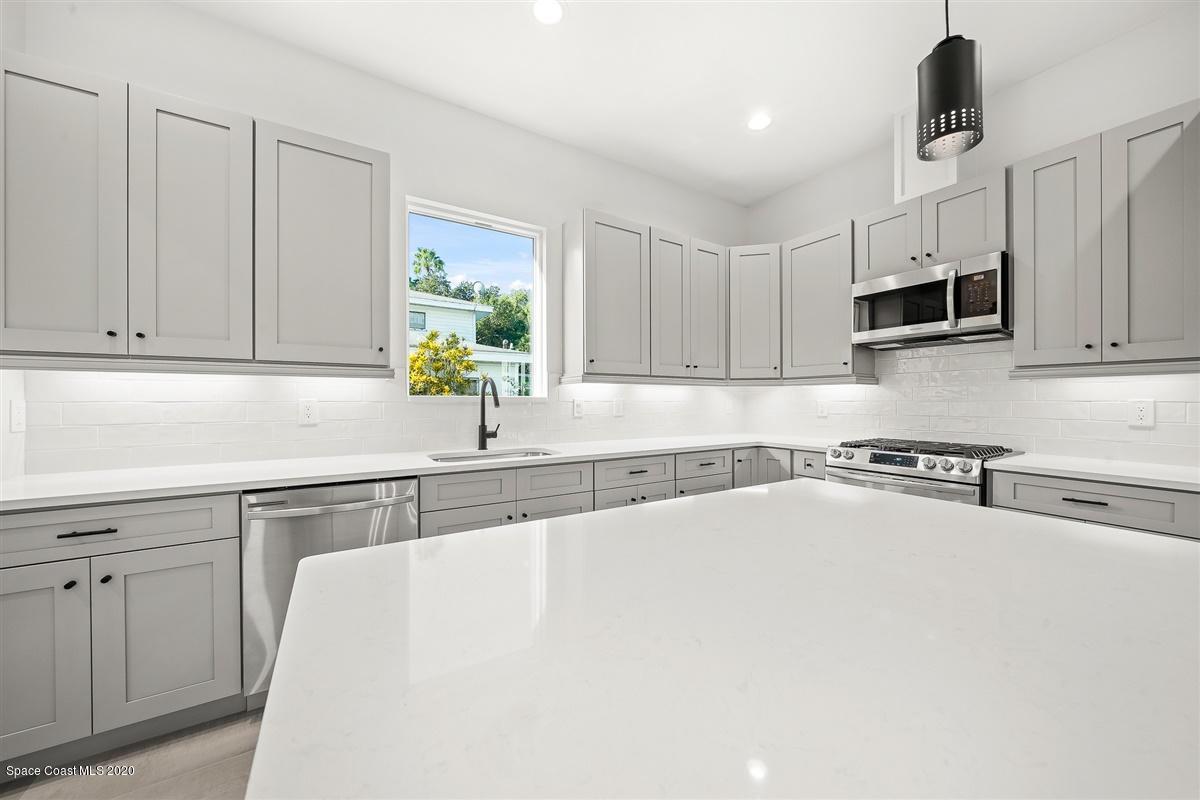 2168 Country Club Road Melbourne, FL 32901 - Photo 12 of 94 a kitchen with granite countertop a sink a counter top space appliances and cabinets