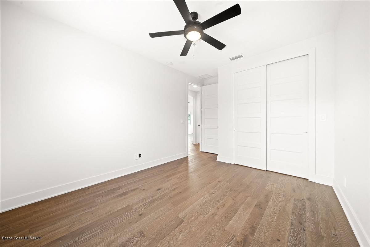 2168 Country Club Road Melbourne, FL 32901 - Photo 43 of 94 a view of a room with wooden floor and a ceiling fan