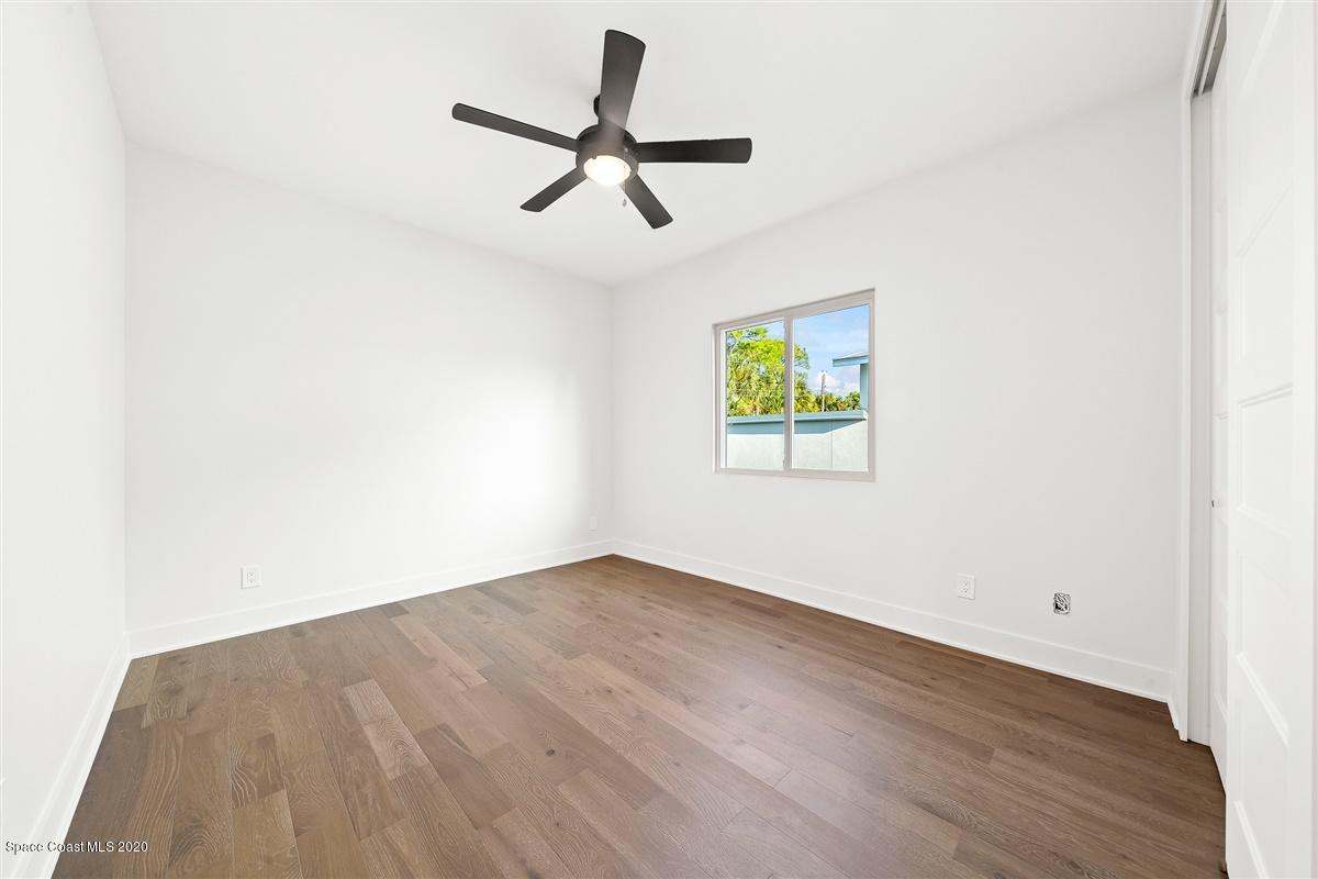 2168 Country Club Road Melbourne, FL 32901 - Photo 45 of 94 an empty room with wooden floor ceiling fan and windows