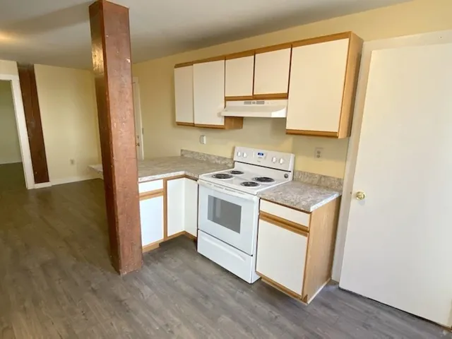 a kitchen with a stove a sink and a window