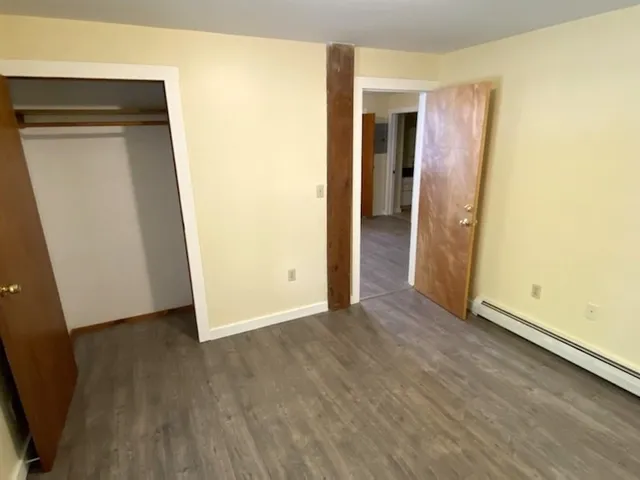 an empty room with wooden floor and closet