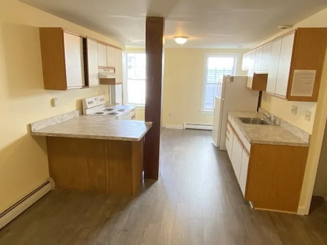 a utility room with wooden floor washer and dryer