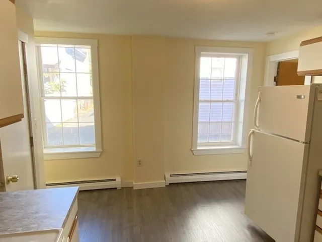an empty room with a window and wooden floor