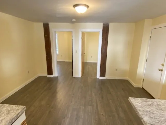 an empty room with wooden floor and a window