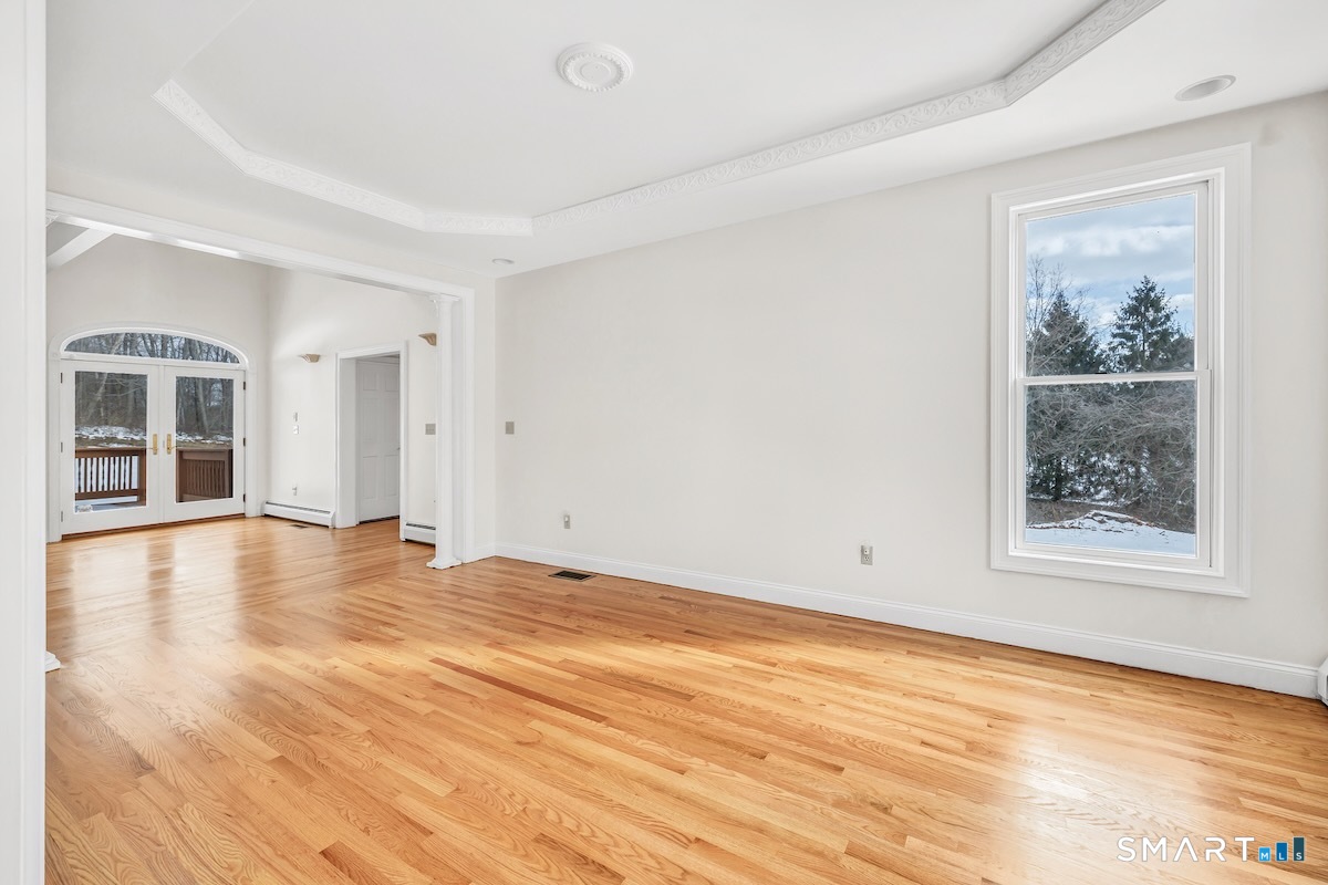461 Amity Road Woodbridge, CT 06525 - Photo 12 of 40 a view of an empty room with wooden floor and a window