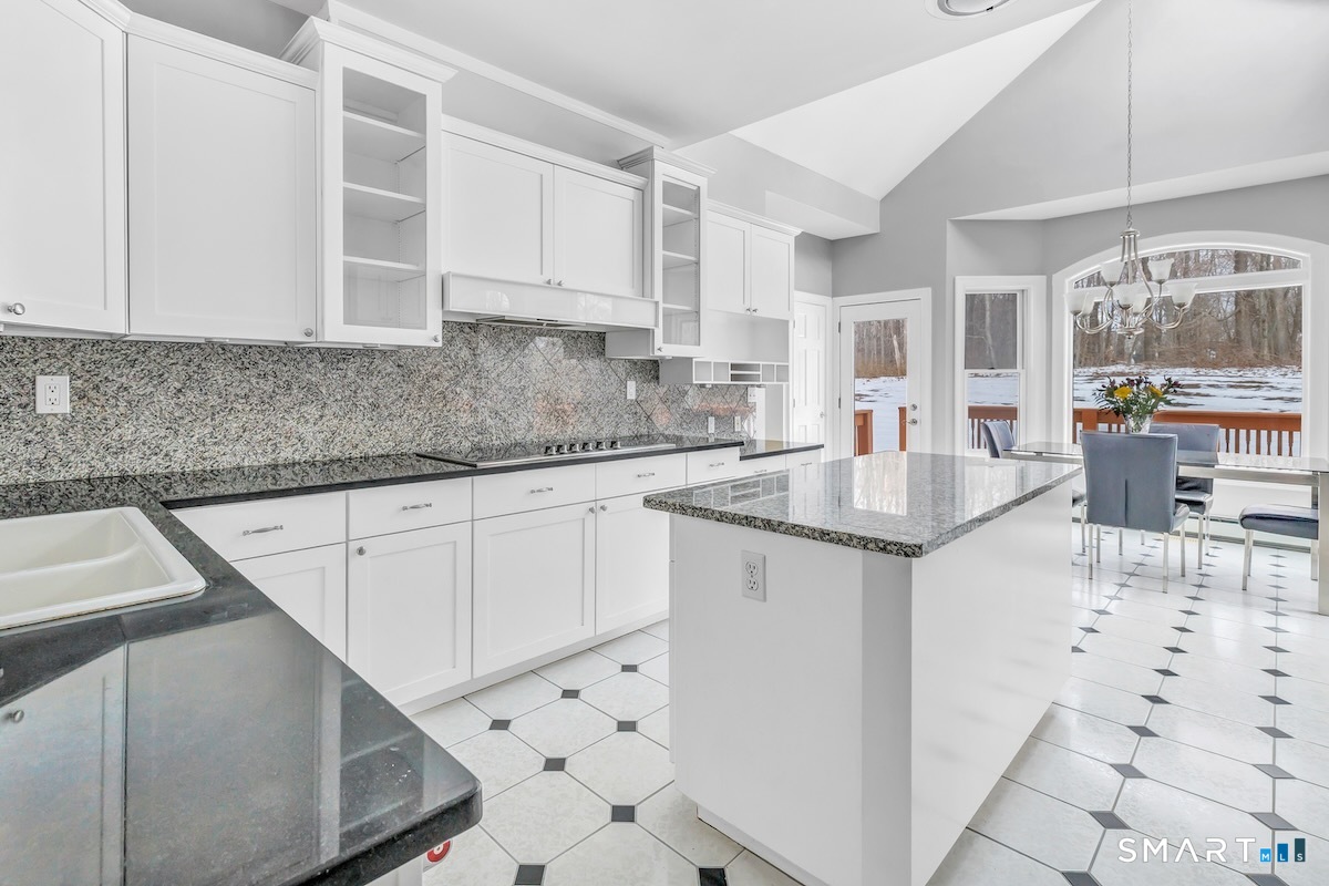 461 Amity Road Woodbridge, CT 06525 - Photo 19 of 40 a kitchen with sink cabinets and chandelier