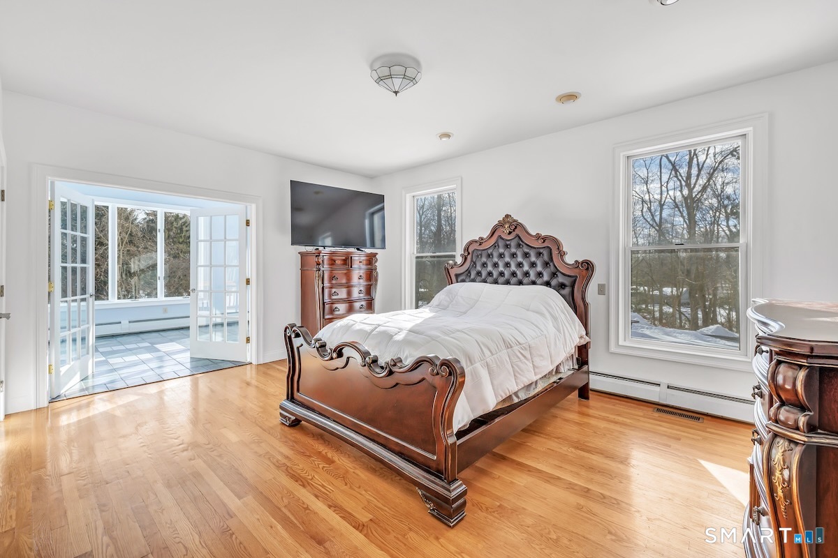 461 Amity Road Woodbridge, CT 06525 - Photo 22 of 40 a spacious bedroom with a bed and wooden floor