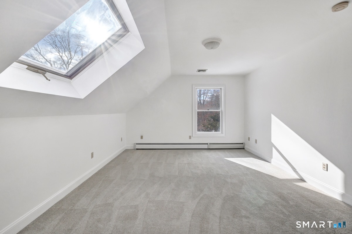 461 Amity Road Woodbridge, CT 06525 - Photo 27 of 40 a view of an empty room with chandelier and a window