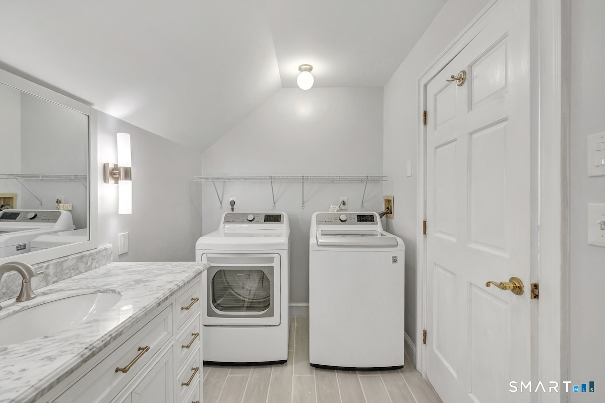 461 Amity Road Woodbridge, CT 06525 - Photo 32 of 40 a utility room with cabinets washer and dryer
