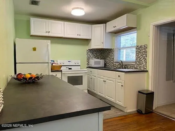 a kitchen with a sink a stove and cabinets