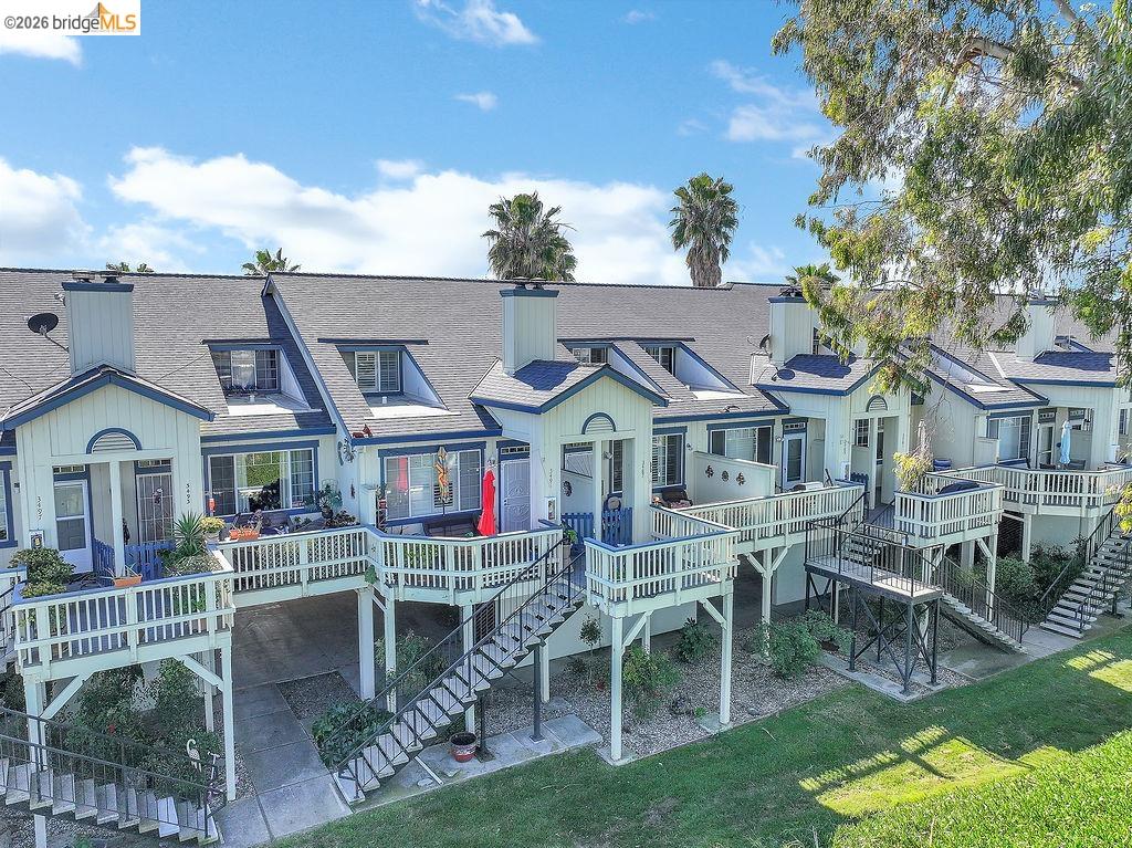 Rear view of house with a chimney, a wooden deck, a shingled roof, and a residential view