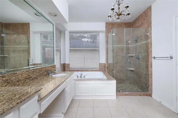 a bathroom with a granite countertop sink a large mirror and a bathtub