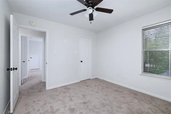 a view of a room with a ceiling fan and a window
