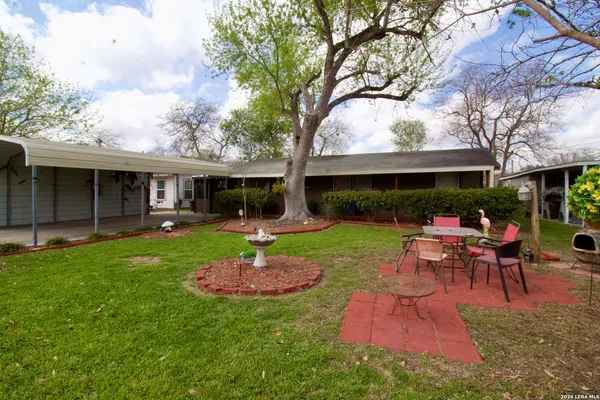 a view of a house with a backyard and a patio