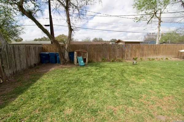 a view of a yard with wooden fence