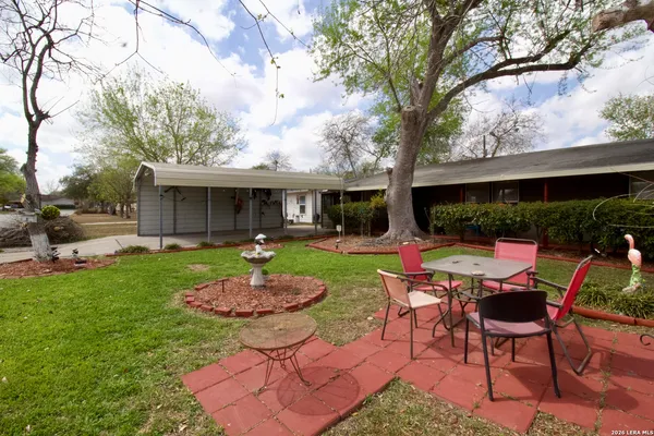 a view of a patio with table chairs and a yard