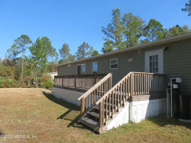 a view of backyard with deck and outdoor seating