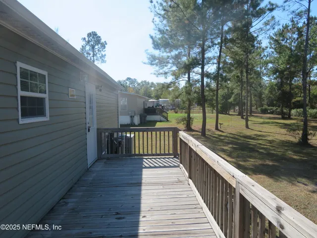 a view of balcony with wooden floor and fence