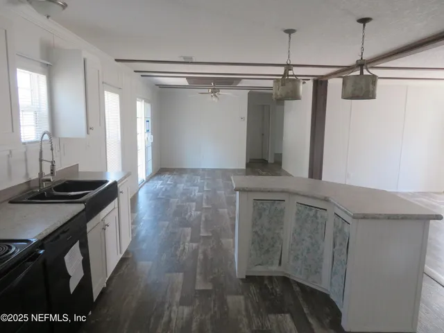 a kitchen with a sink and wooden floor