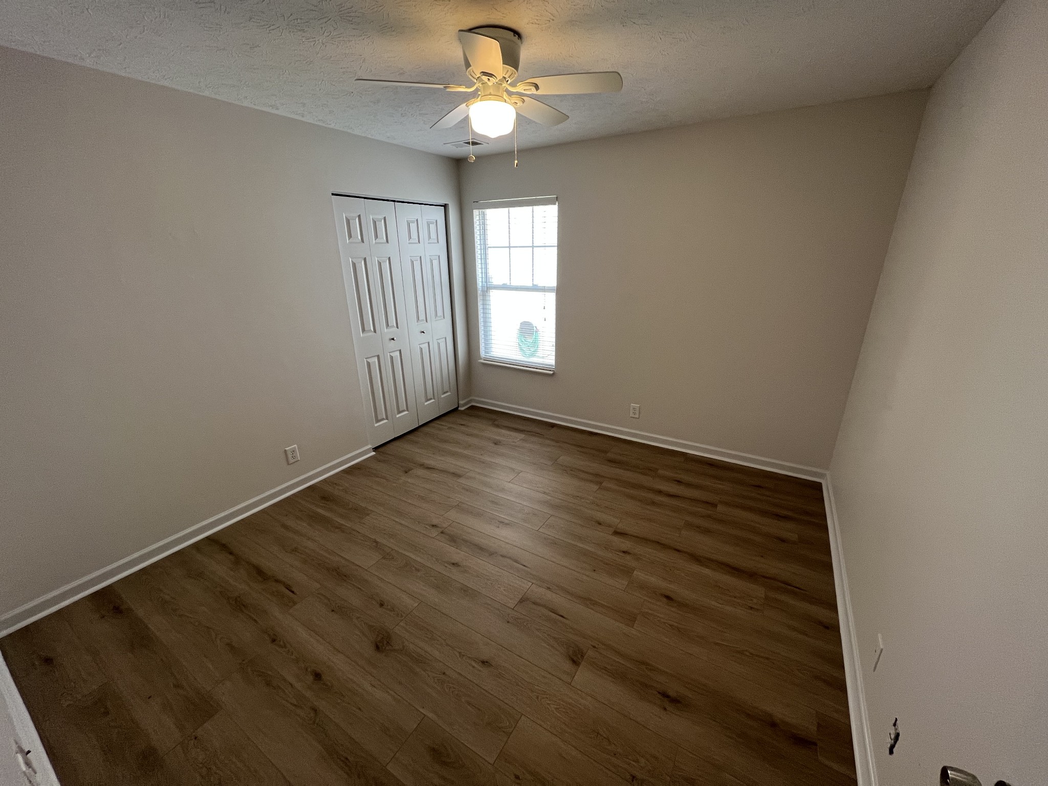 3965 Stephens Ridge Way Antioch, TN 37013 - Photo 13 of 17 an empty room with wooden floor chandelier fan and windows