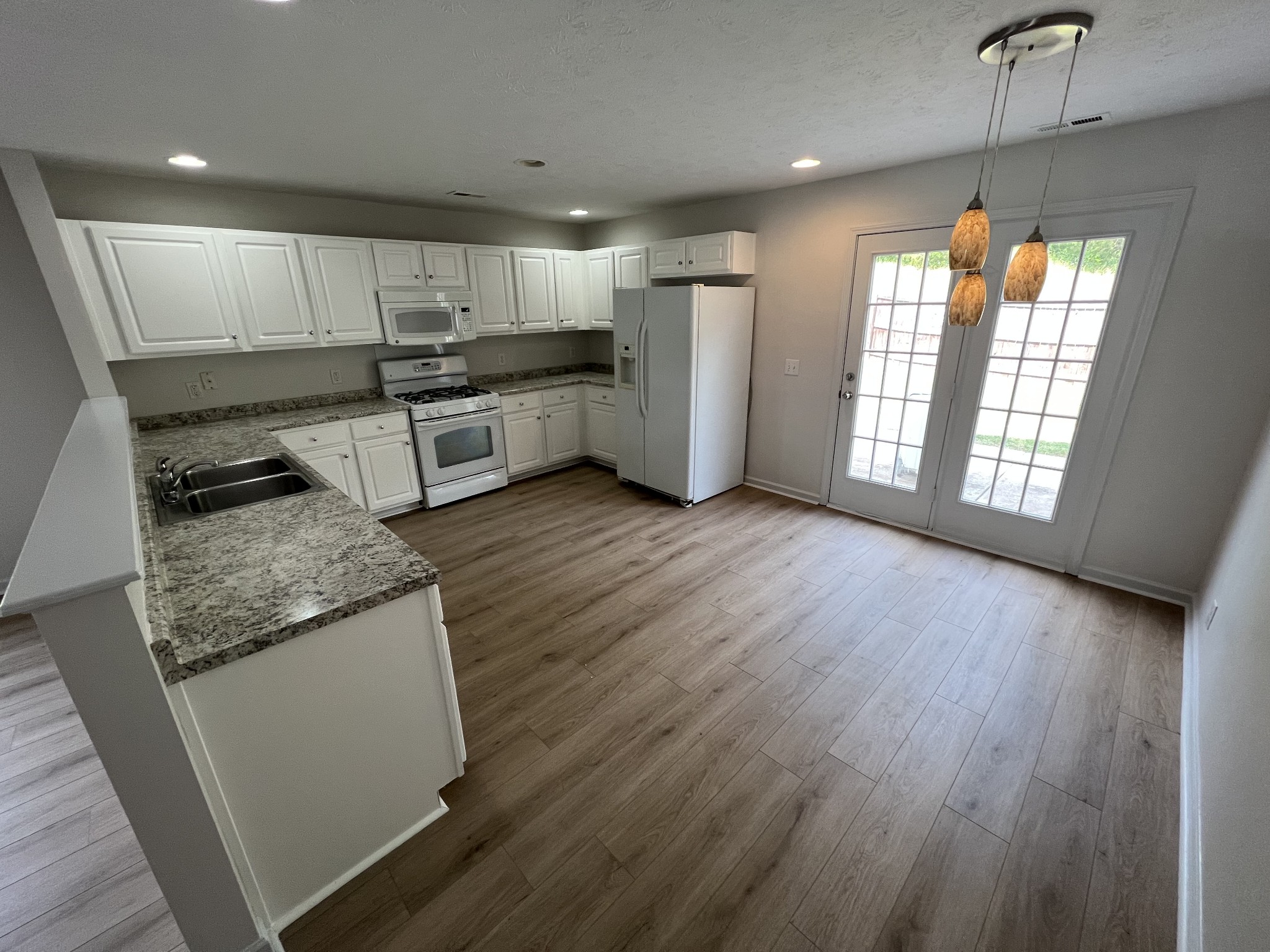 3965 Stephens Ridge Way Antioch, TN 37013 - Photo 6 of 17 a kitchen with stainless steel appliances granite countertop a refrigerator a sink dishwasher a stove and a large window with wooden floor