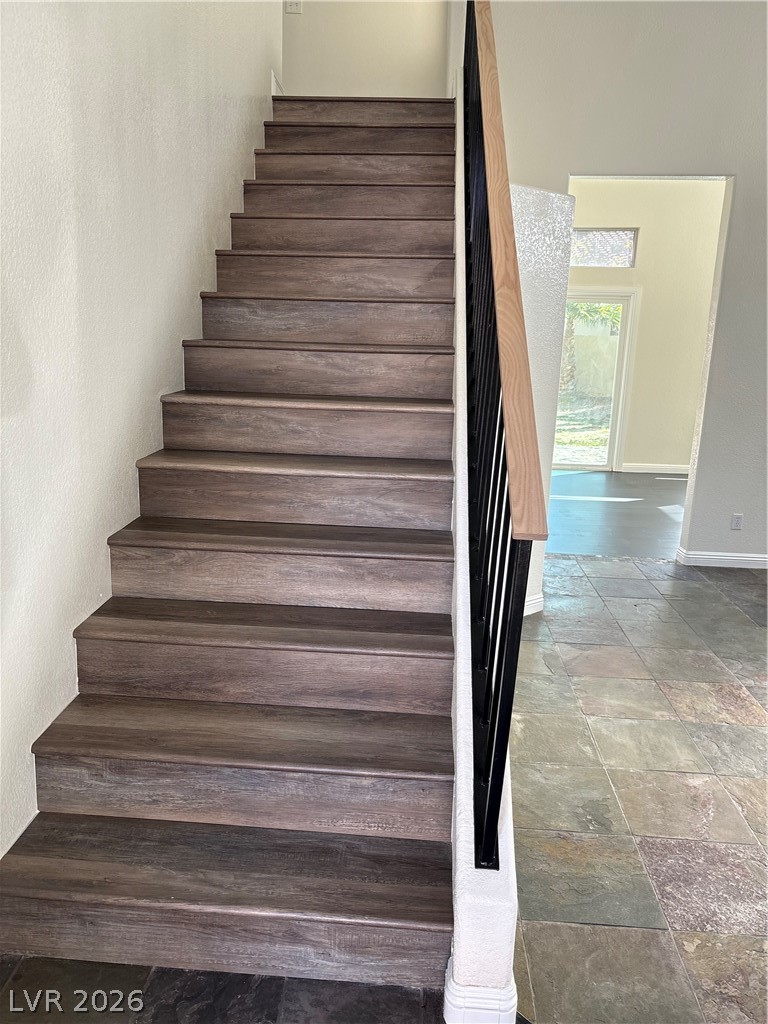 2670 Ridgewater Circle Henderson, NV 89074 - Photo 10 of 22 This living space features a refined staircase with wooden risers and a durable stone wall.