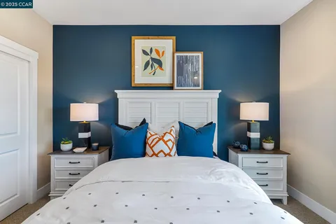 a bedroom with a bed and a lamp on dresser