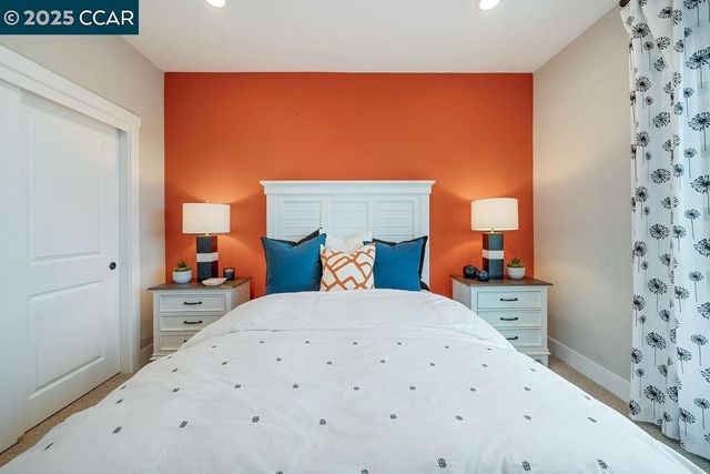 a bedroom with a bed and a white wall next to a window