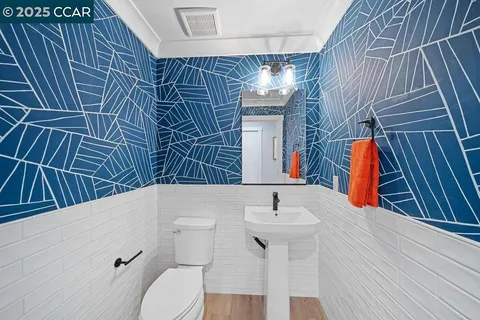 a bathroom with a sink and mirror with toilet