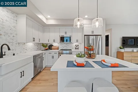 a kitchen that has a lot of cabinets and stainless steel appliances