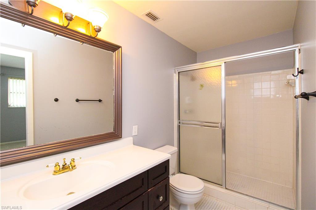 729 Palm View Drive, Unit D4 Naples, FL 34110 - Photo 18 of 23 a bathroom with a granite countertop sink toilet and shower