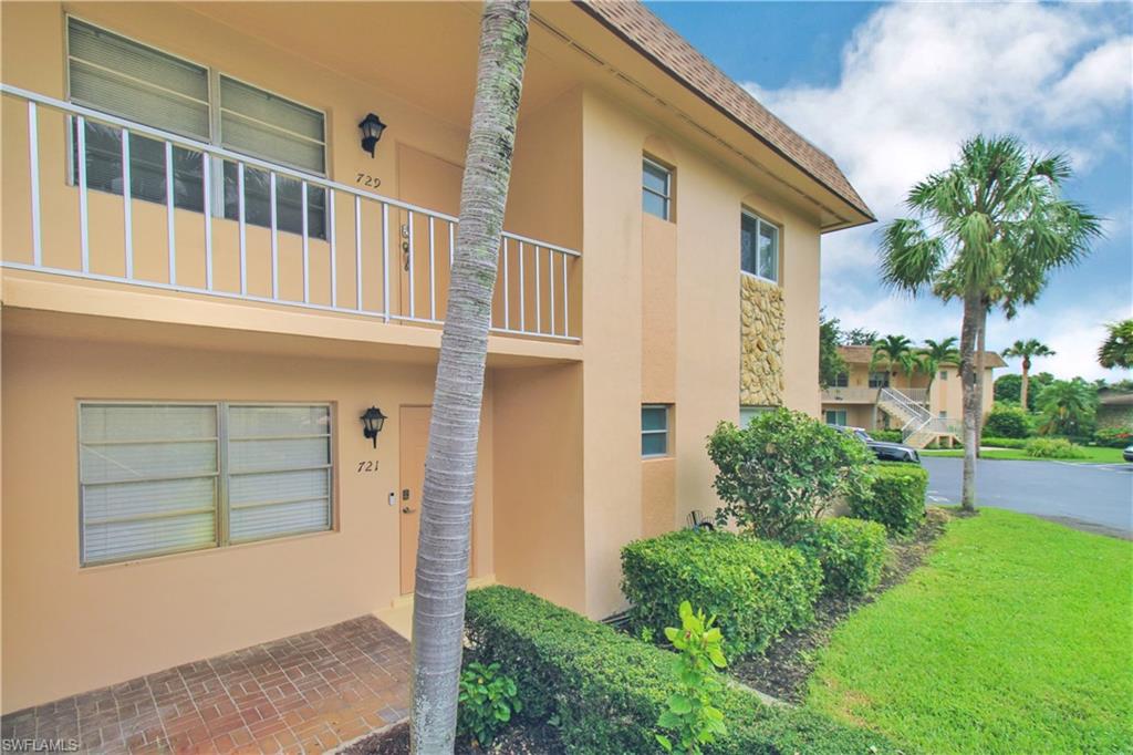 729 Palm View Drive, Unit D4 Naples, FL 34110 - Photo 2 of 23 a front view of a house with a yard